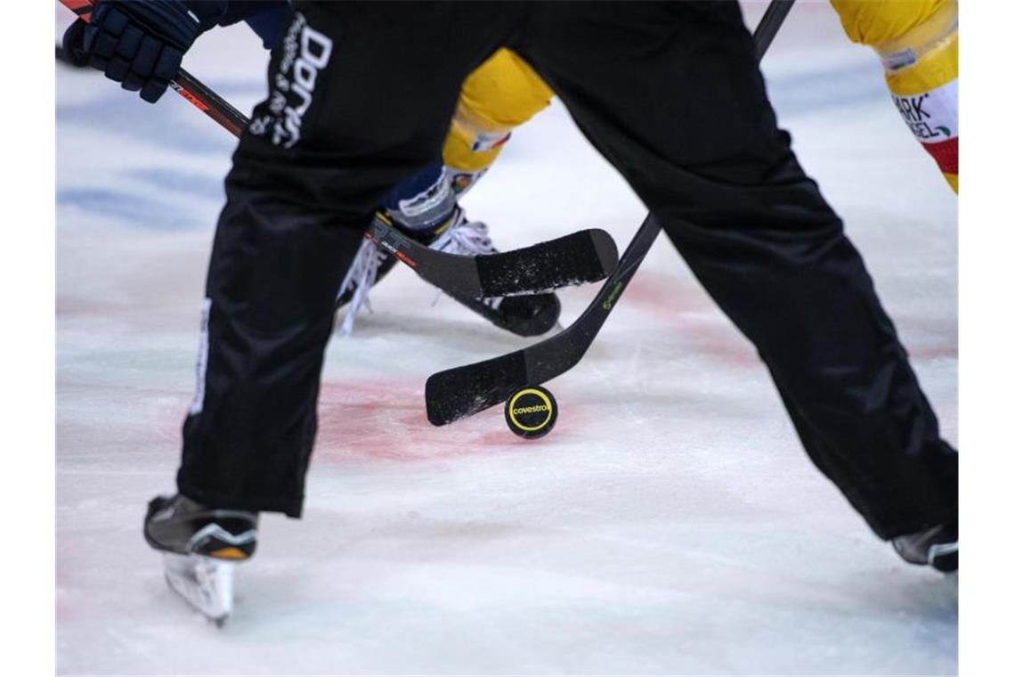 Eishockeyspieler kämpfen nach dem Bully um den Puck. Foto: Bernd Thissen/dpa/Symbolbild