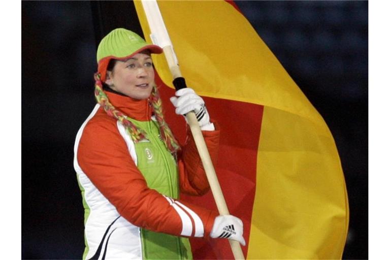 Eisschnelläuferin Claudia Pechstein trägt 2006 bei der Abschlussfeier der Olympischen Winterspiele in Turin die deutsche Fahne. Foto: Matthias Schrader/dpa