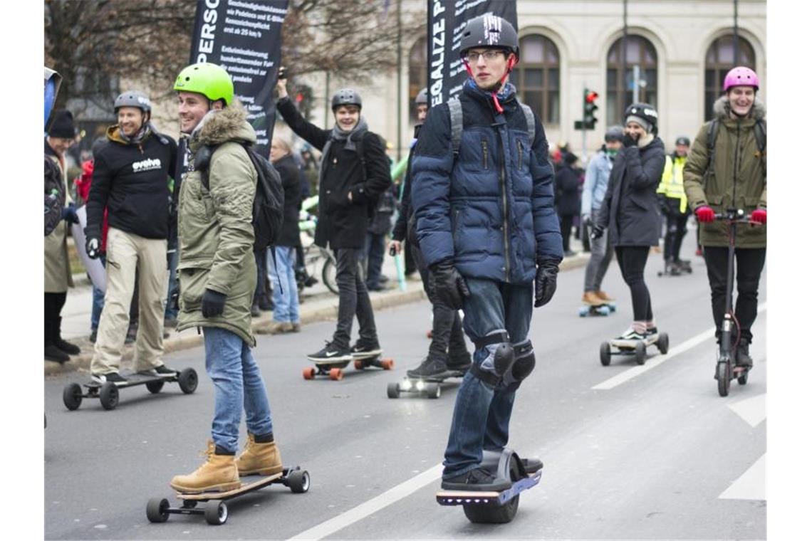 Die E-Tretroller kommen - auf Radwegen und ab 14 Jahren Elektrisch unterwegs: Anhänger der Elektro-Tretroller und E-Skateboards vor dem Bundesverkehrsministerium in Berlin. Foto: Clo Catalan