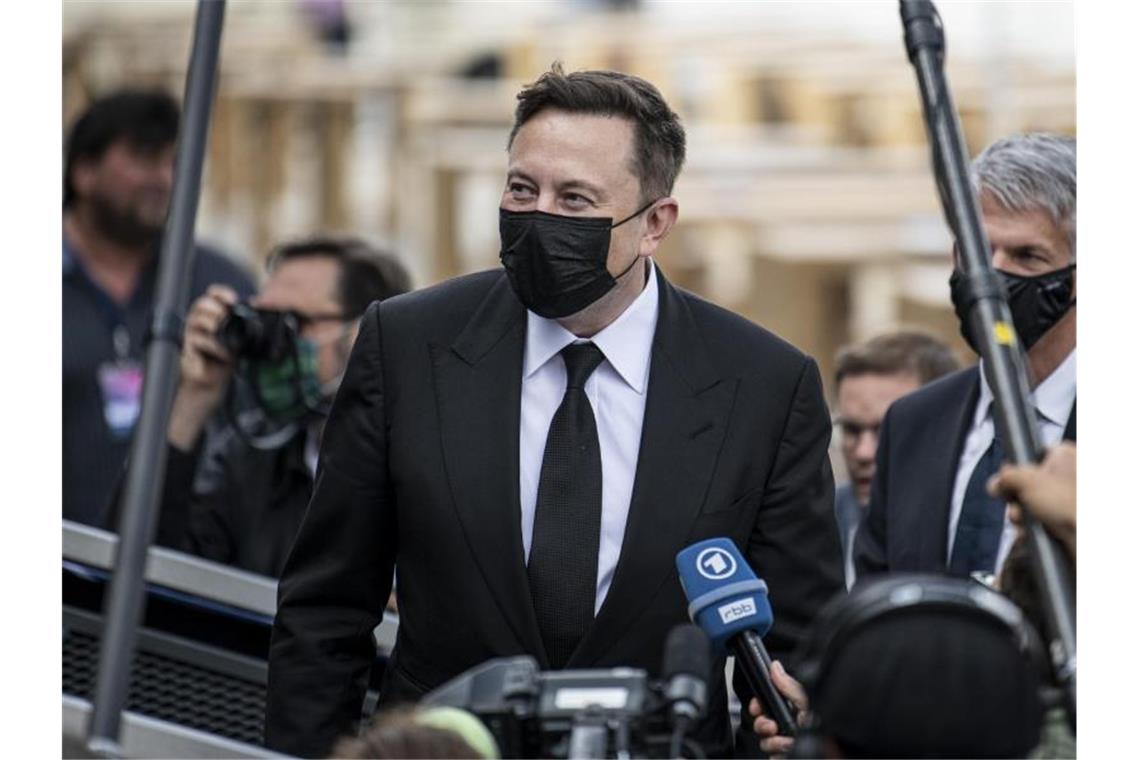 Elon Musk (M) kommt mit Mundschutz zur Fraktionsklausur der Union im Berliner Westhafen. Foto: Fabian Sommer/dpa
