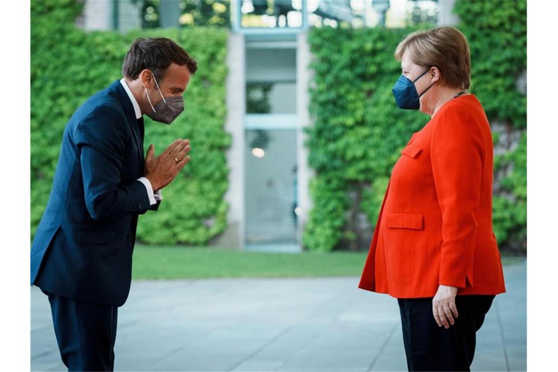 Emmanuel Macron begrüßt Angela Merkel vor dem Bundeskanzleramt. Foto: Kay Nietfeld/dpa