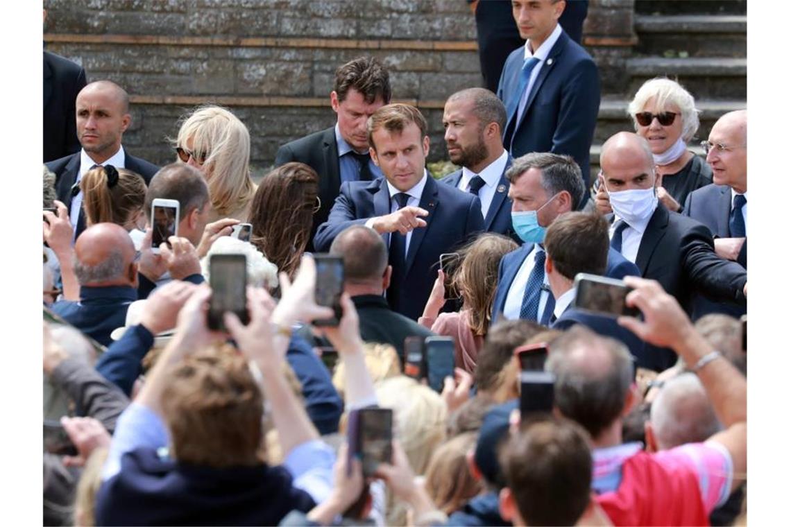 Emmanuel Macron (hinten,M) nach der Stimmabgabe im nordfranzösischen Seebad Le Touquet. Foto: Ludovic Marin/AFP/dpa