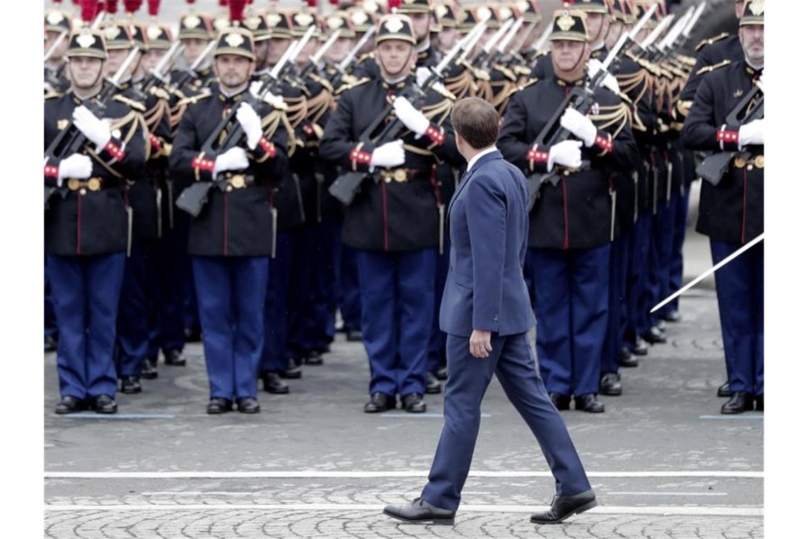 Emmanuel Macron inspiziert die Truppen auf den Champs-Élysées. Foto: Lewis Joly/AP/dpa