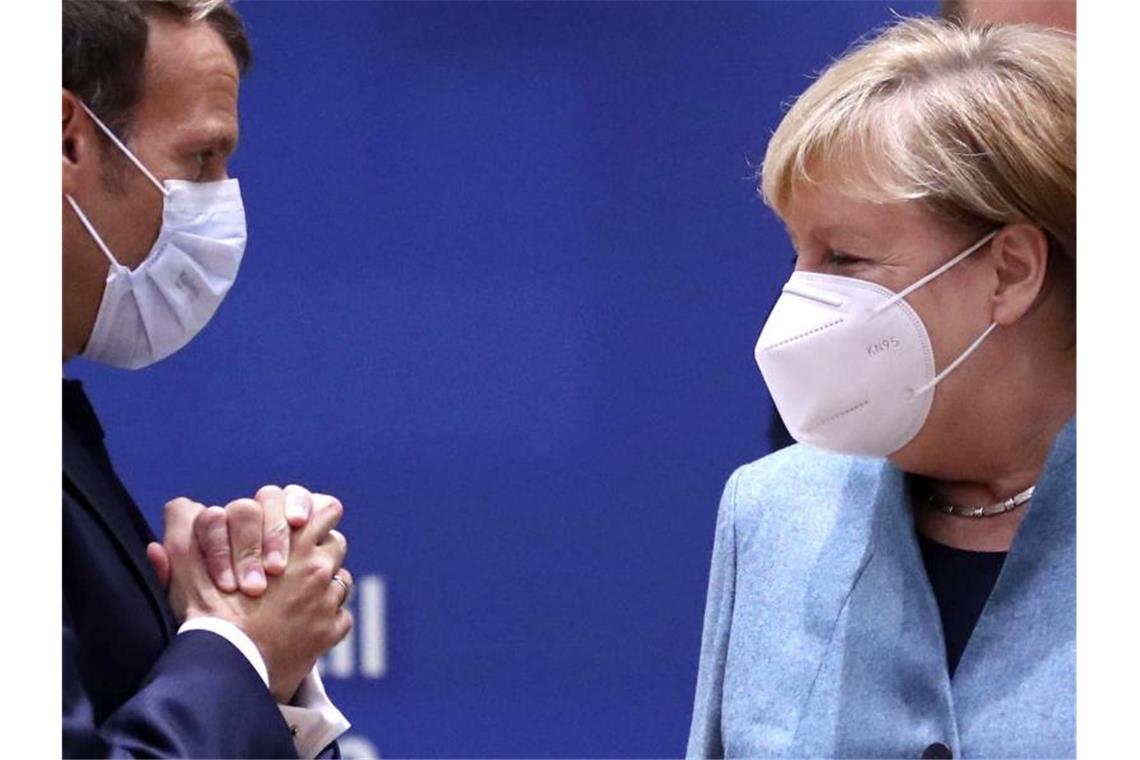 EU-Gipfel: Klare Kante im Brexit-Streit Emmanuel Macron (l), Präsident von Frankreich, und Bundeskanzlerin Merkel sprechen während einer Diskussion am runden Tisch im Rahmen des EU-Gipfels. Foto: Yves Herman/Reuters Pool/AP/dpa