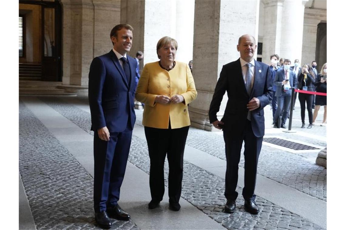 Deutsches Duett: Merkel präsentiert Scholz auf der Weltbühne Emmanuel Macron (l-r), Präsident von Frankreich, begrüßt Angela Merkel (CDU), geschäftsführende Bundeskanzlerin, und Olaf Scholz (SPD), Bundesfinanzminister und Kanzlerkandidat, vor einem Treffen der Europäischen Union und der Afrikanischen Union in der französischen Botschaft. Foto: Gregorio Borgia/Pool AP/dpa
