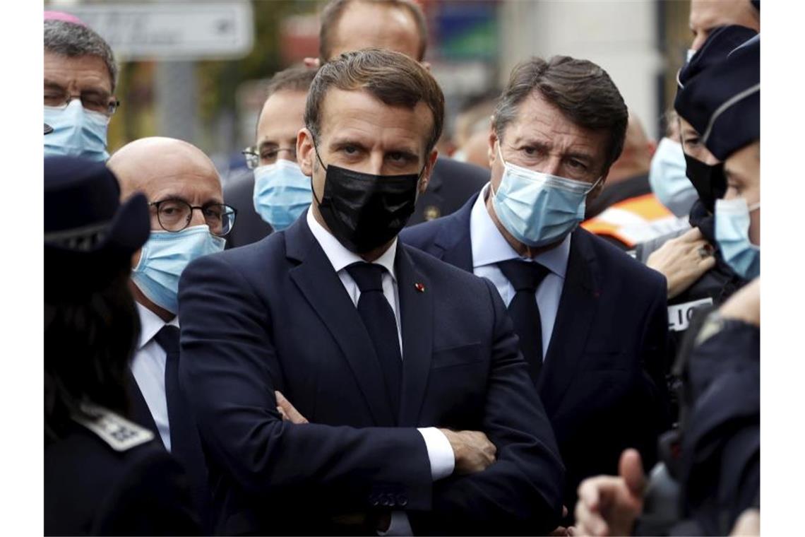 Emmanuel Macron (M, link), Präsident von Frankreich, und Christian Estrosi (M, rechts), Bürgermeister von Nizza, treffen sich nach der Messerattacke in der Kirche Notre-Dame. Foto: Eric Gaillard/Pool Reuters/dpa