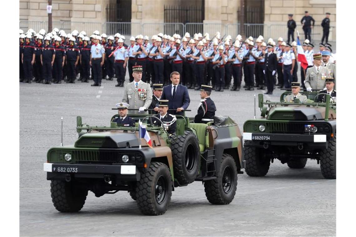 Emmanuel Macron, Präsident von Frankreich, und Francois Lecointre, Chef des französischen Generalstabs, inspizieren Truppen vor der Militär-Feier. Foto: Ludovic Marin/AFP/dpa