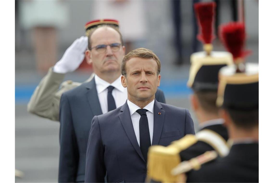 Präsident Macron bereitet Franzosen auf harte Zeiten vor Emmanuel Macron (r), Präsident von Frankreich, und Jean Castex, Premierminister von Frankreich, inspizieren Truppen vor der Militär-Feier. Foto: Christophe Ena/AP/dpa