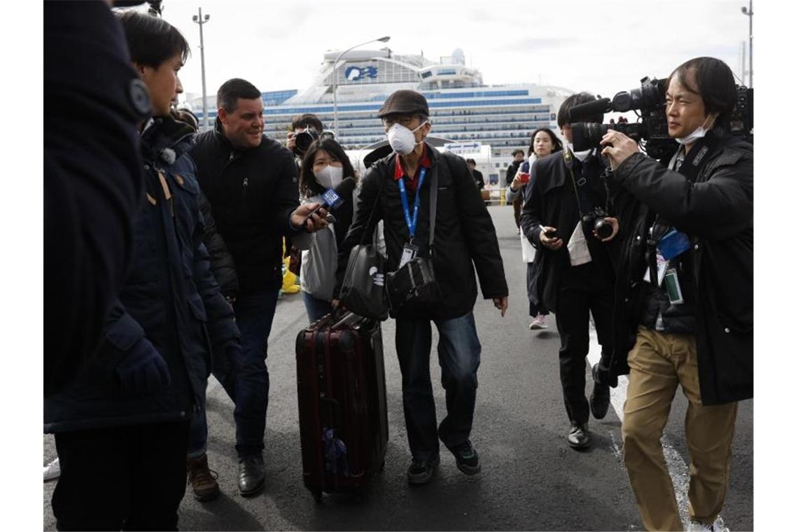 Endlich an Land: Ein Passagier wird von Journalisten empfangen, nachdem er das Kreuzfahrtschiff „Diamond Princess“ verlassen hat. Foto: Jae C. Hong/AP/dpa