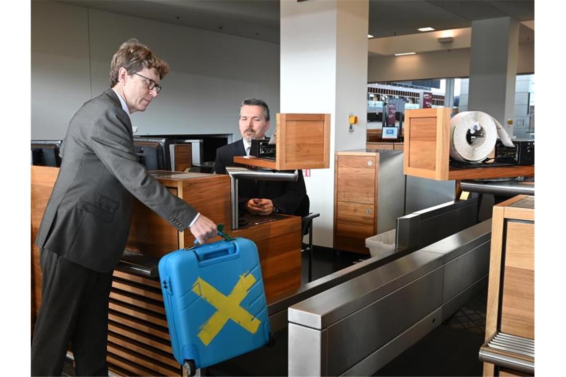 Engelbert Lütke-Daldrup, Vorsitzender der Geschäftsführung der Flughafen Berlin Brandenburg GmbH, gibt zum Probebetrieb einen Koffer auf. Foto: Bernd Settnik/dpa-Zentralbild/dpa
