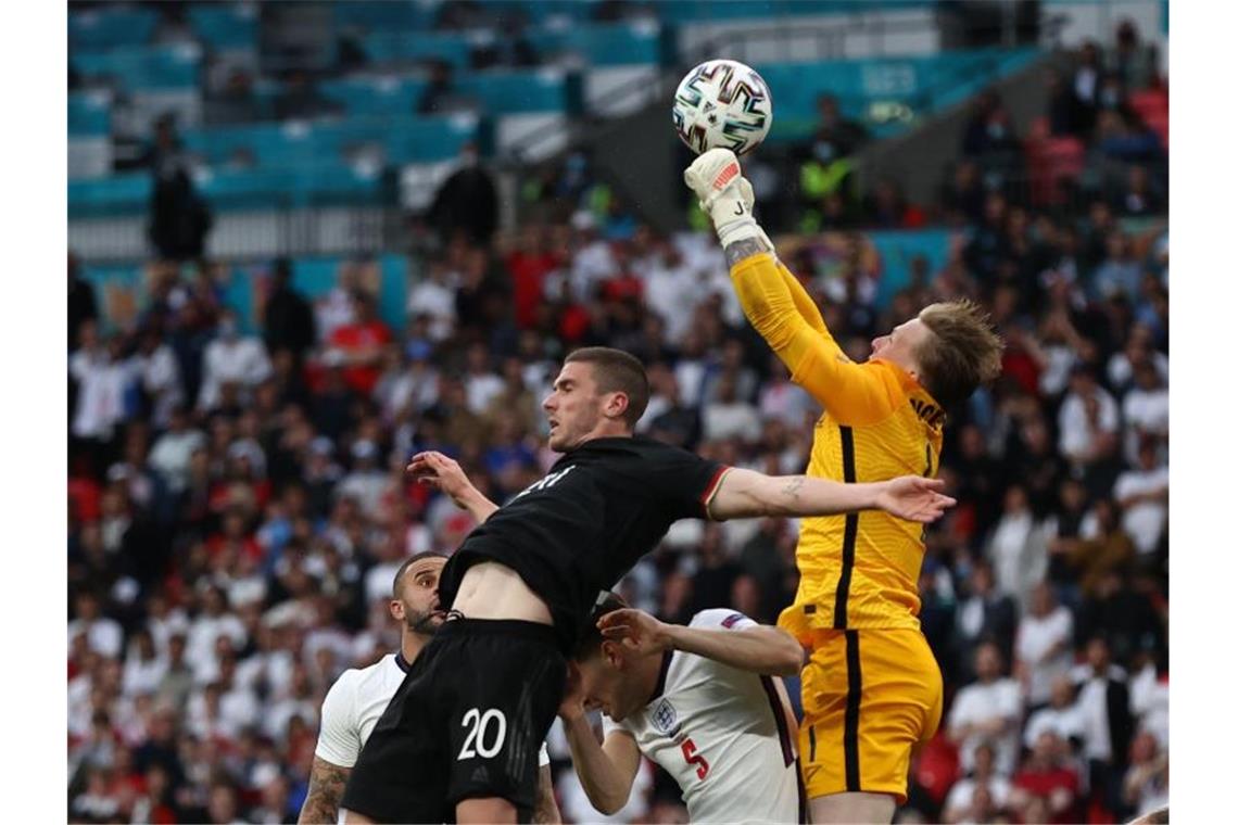 England-Keeper Jordan Pickford (r) klärt in der Luft vor DFB-EM-Entdeckung Robin Gosens. Foto: Christian Charisius/dpa