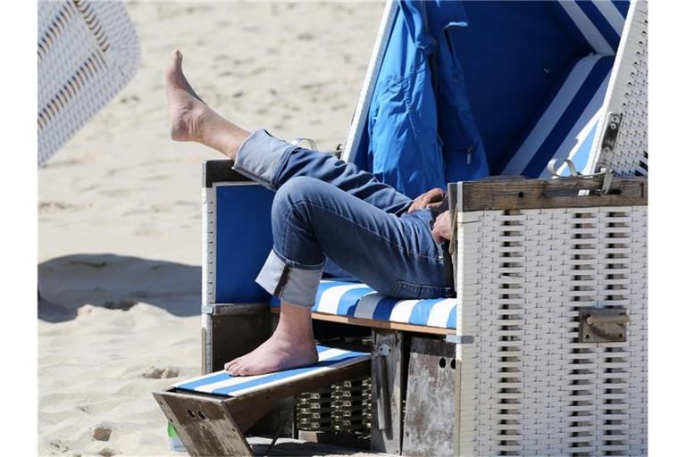 Entspannung im Strandkorb an einem Strand in Schleswig-Holstein. Foto: Bodo Marks/dpa