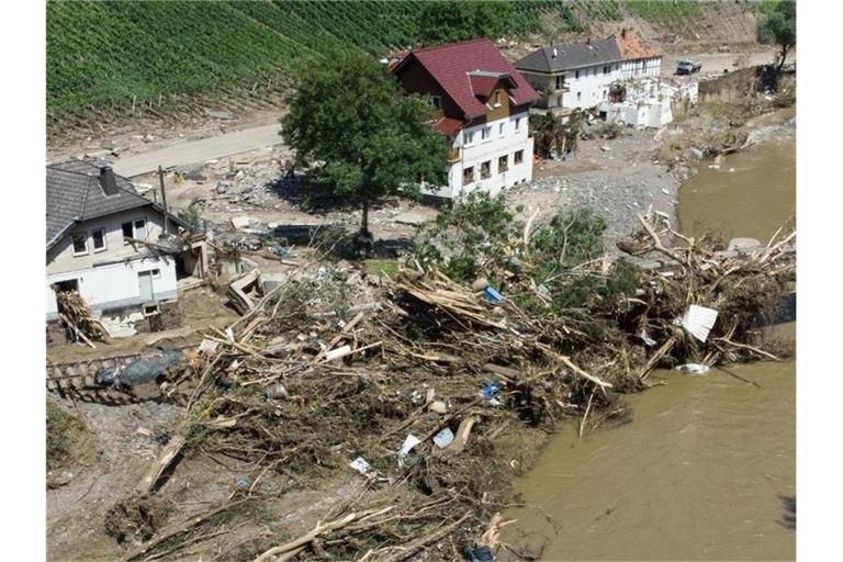 Entwurzelte Bäume liegen nach dem Unwetter neben komplett zerstörten Häusern am Ufer der Ahr in Marienthal. Foto: Boris Roessler/dpa