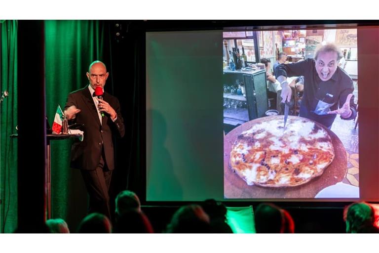 Eric Pfeil liest im Stuttgarter Kulturzentrum Merlin aus seinem Buch „Hotel Celentano“ und zeigt dabei ein Bild von riesigen Pizzen. Foto: Lichtgut/Christoph Schmidt