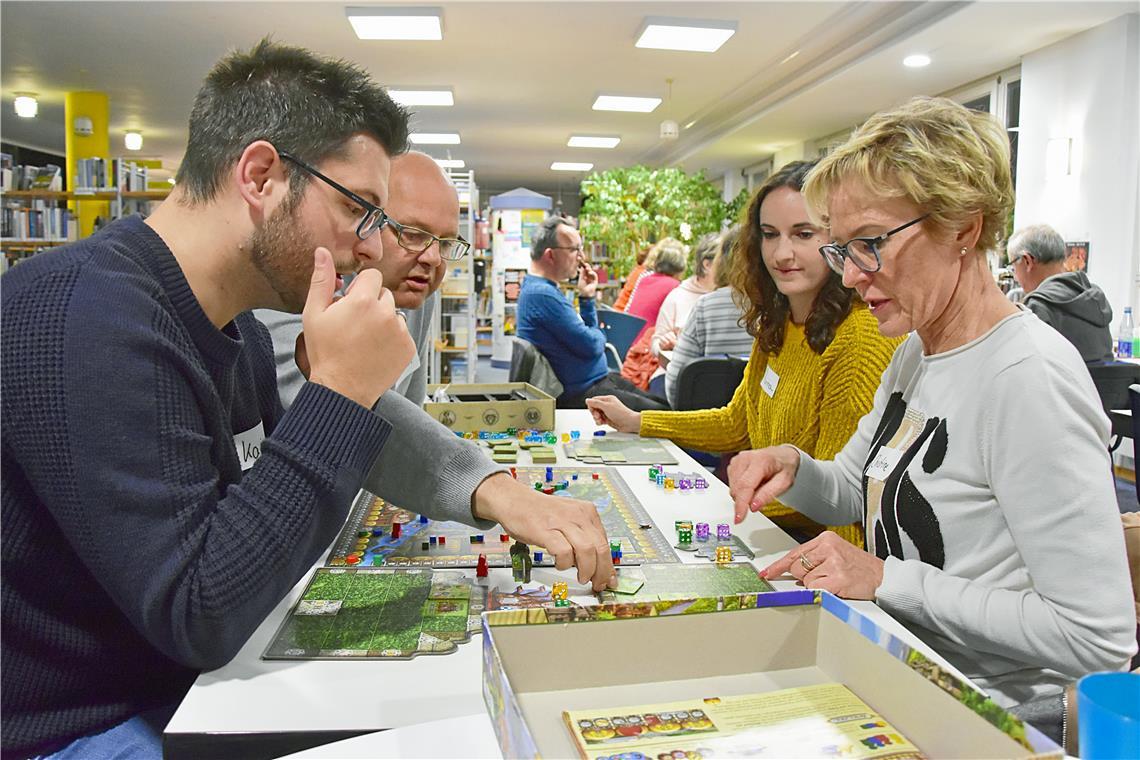 Beim Spieletreff in der Stadtbücherei gibt es nur Gewinner „Erklärbär“ Bernd (hinten links) zeigt Kai (von links), Marina und Christine, wie ihr ausgesuchtes Spiel funktioniert. Foto: Tobias Sellmaier