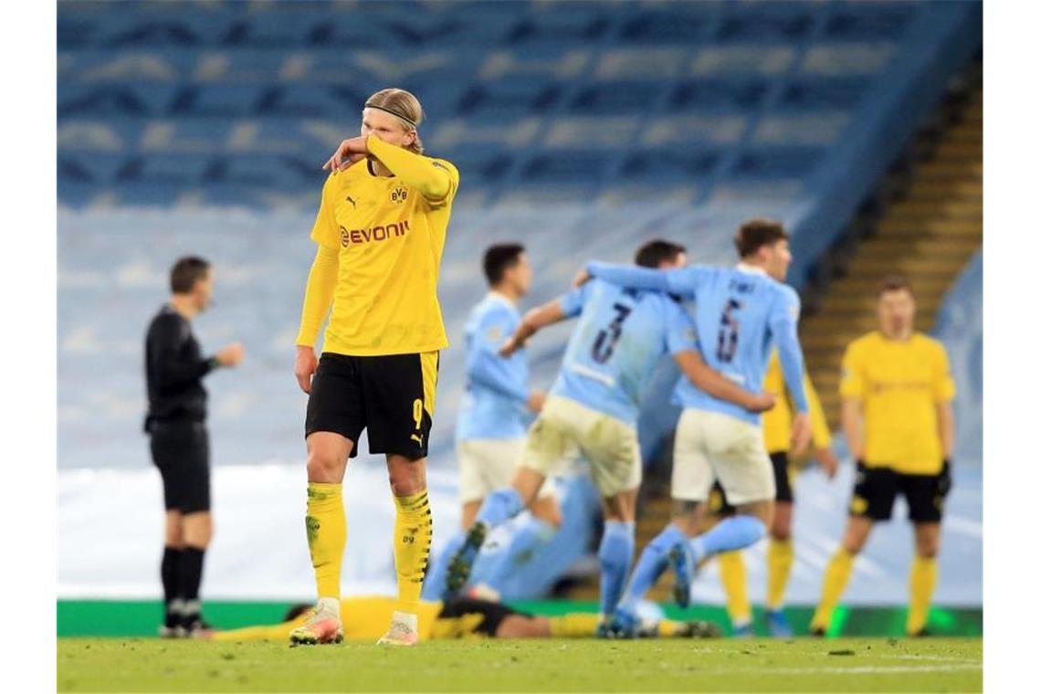 Erling Haaland steht nach dem Last-Minute-Tor von Manchester City enttäuscht auf dem Platz. Foto: Lindsey Parnaby/dpa