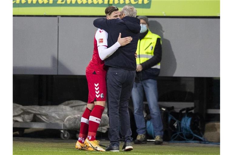Ermedin Demirovic (l) und Trainer Christian Streich umarmen sich. Foto: Tom Weller/dpa/Archivbild