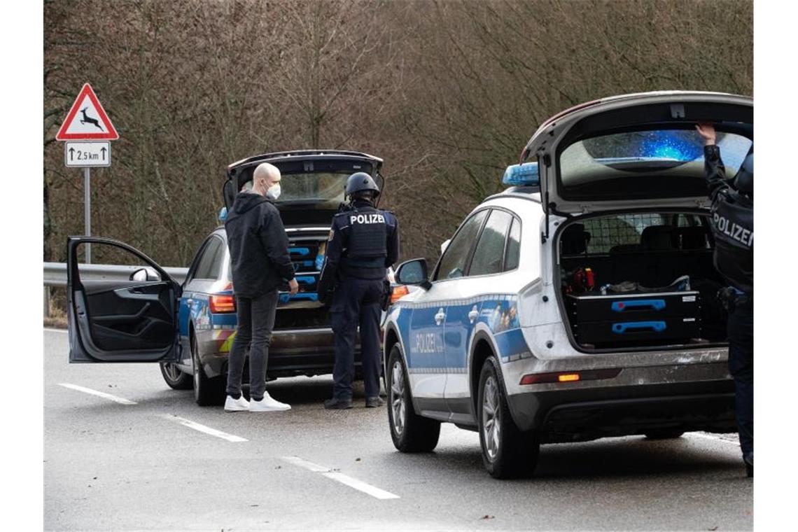 Polizisten erschossen - Zwei Verdächtige festgenommen Ermittler stehen auf einer Straße nahe des Ortes Mayweilerhof. Foto: Sebastian Gollnow/dpa