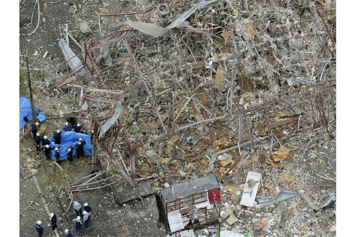 Ermittler untersuchen das völlig zerstörte Gebäude nach einer Explosion. Foto: Uncredited/Kyodo News/AP/dpa
