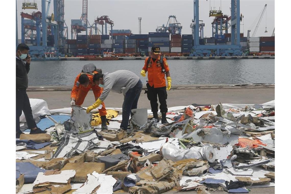 Ermittler untersuchen Wrackteile der Boeing 737 Max 8 der Lion Air an der Absturzstelle. Foto: Tatan Syuflana/AP/dpa