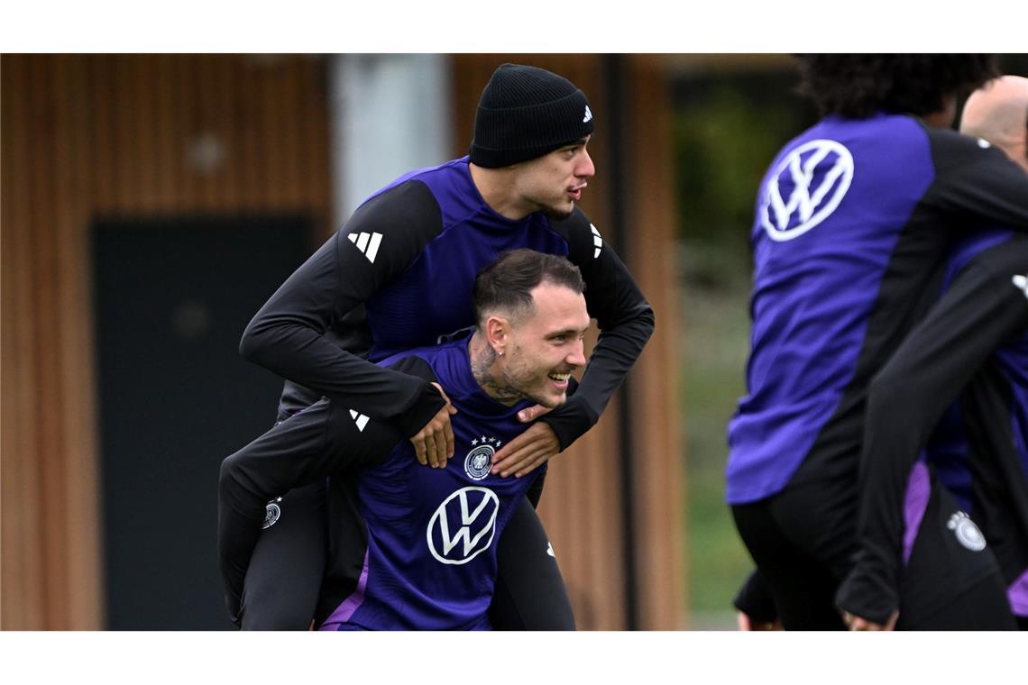 Erst Huckepack dann Doppelpack? Beim Training der Fußball-Nationalmannschaft vor dem WM-Quali-Spiel gegen Luxemburg trägt David Raum Aleksandar Pavlovic auf den Schultern.