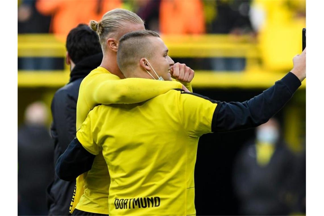 Erst Matchwinner, dann mit Fannähe: Dortmunds Stürmer Erling Haaland macht nach dem Sieg gegen Mainz ein Selfie mit einem Fan. Foto: Bernd Thissen/dpa