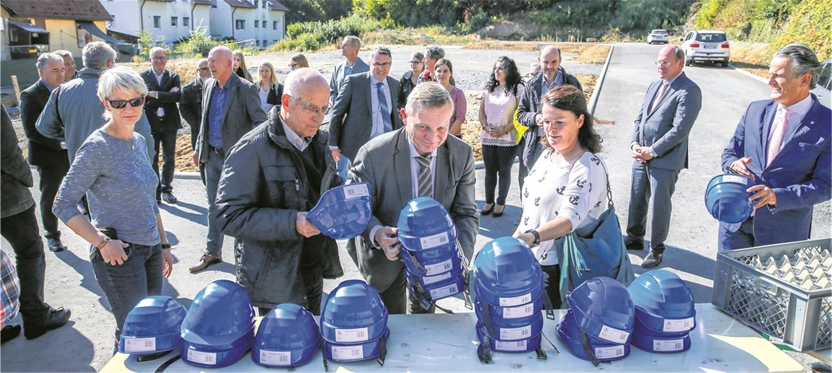 Erster Bürgermeister Siegfried Janocha verteilt die Helme für den Spatenstich, die Stadträte Sabine Kutteroff und Gerhard Ketterer greifen zu. Nach den Lokalpolitikern übernehmen in Kürze die Bauarbeiter an der Mühlstraße das Kommando. Foto: A. Becher