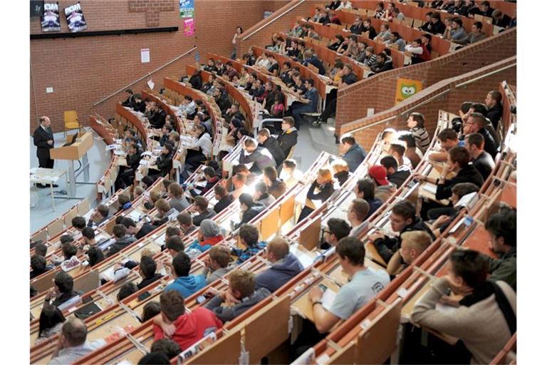 Erstsemester sitzen in einem Hörsaal der Universität und nehmen an der Einführungsveranstaltung in Maschinenbau teil. Foto: Uwe Zucchi/dpa
