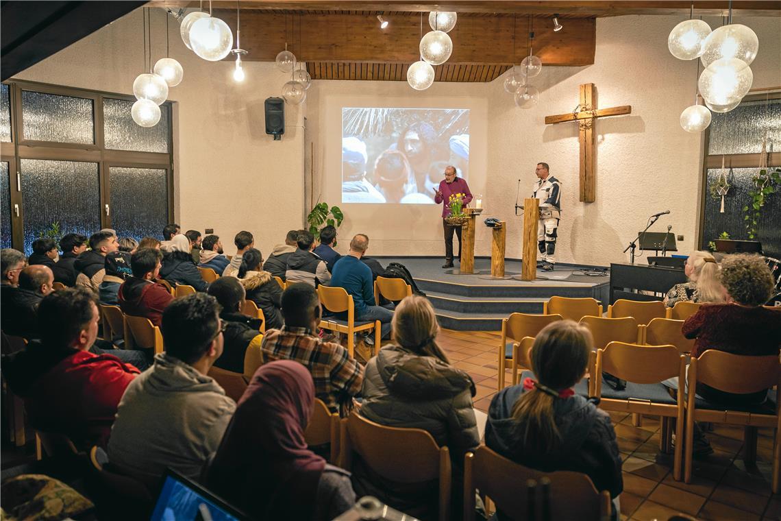 Treff 18 in Backnang ermöglicht Freundschaft über Glaubensgrenzen hinweg Erwin Häcker (auf der Bühne links) spricht beim Treff 18 über eine biblische Geschichte, Kamal Jolo übersetzt. Foto: Alexander Becher