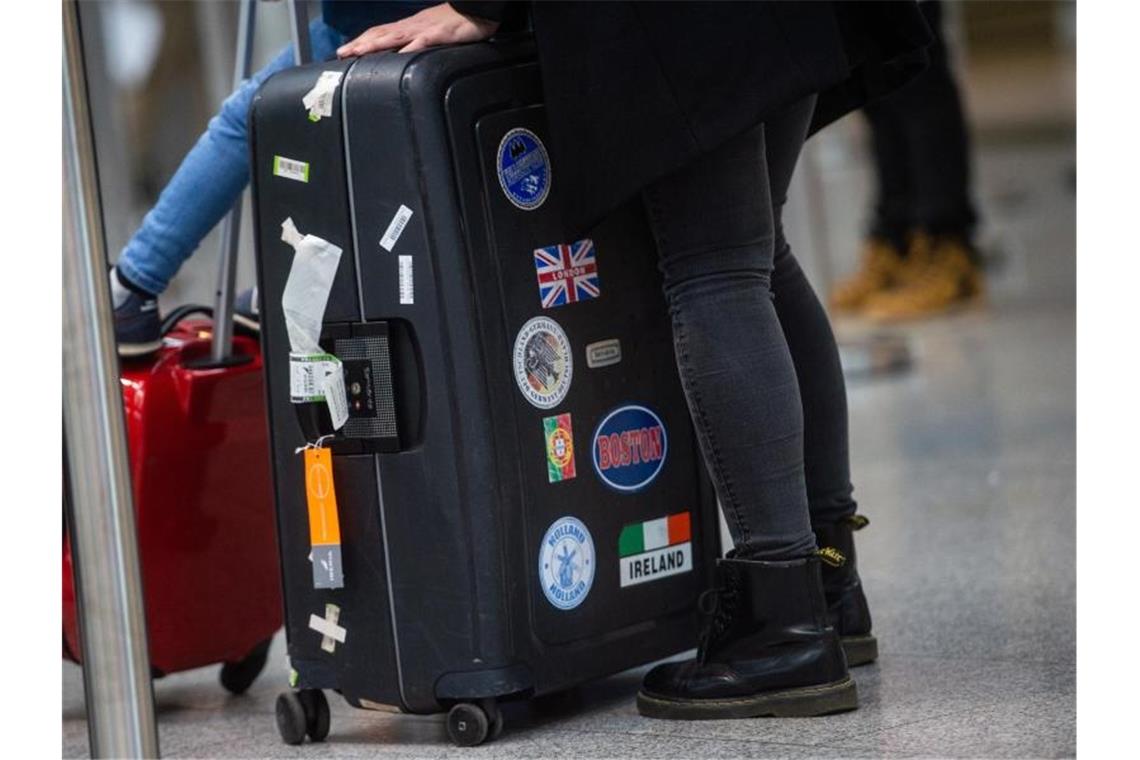 Viele legen die Urlaubsplanung wegen Corona auf Eis „Es gibt aktuell kaum Tourismus“: Eine Familie mit ihrem Gepäck an einem Flughafen. Foto: Jonas Güttler/dpa