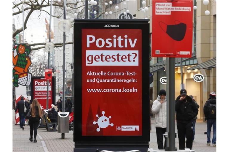Es ist noch nicht vorbei: eine Corona-Hinweistafel in der Kölner Innenstadt. Foto: Oliver Berg/dpa