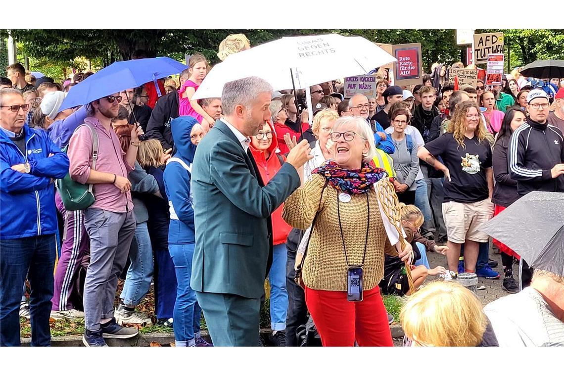 Palmer sieht nach Debatte mit AfD-Landeschef keinen Sieger Es regnet kurzzeitig. Eine Frau reicht Palmer einen Schirm.