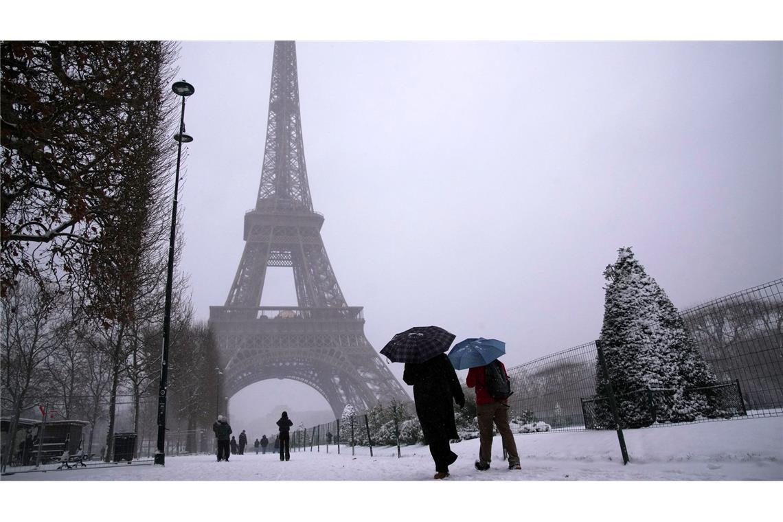 Es schneit unter dem Eiffelturm.