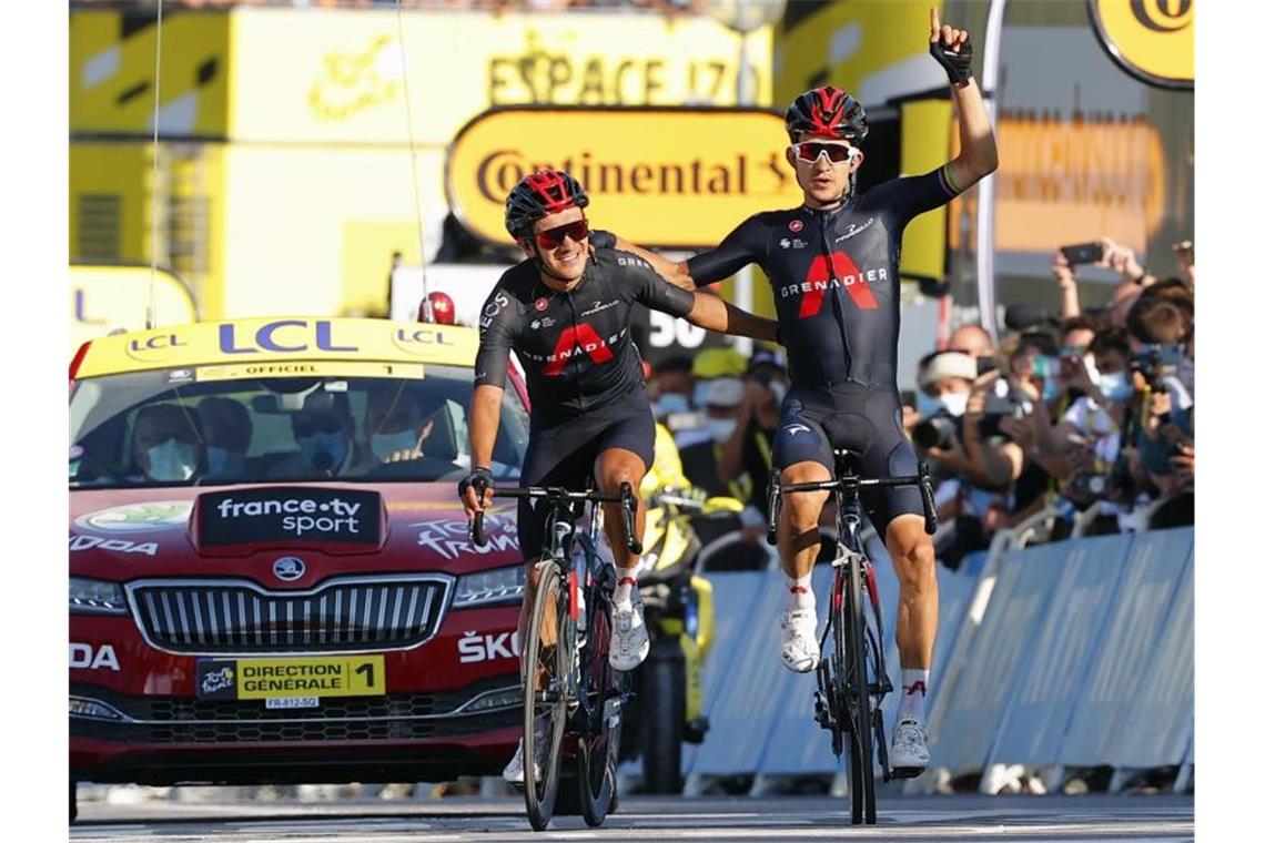 Etappensieger Michal Kwiatkowski (r) und Richard Carapaz fuhren Arm in Arm über die Ziellinie. Foto: Pool/BELGA/dpa