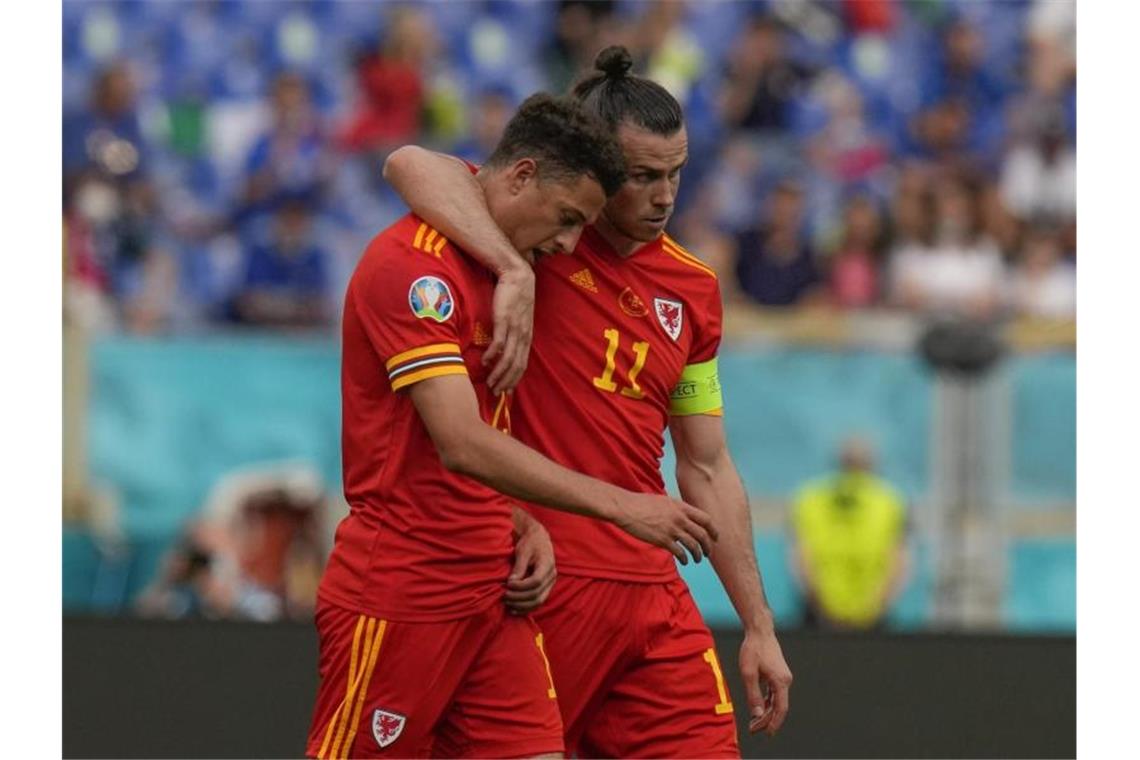 Ethan Ampadu (l) aus Wales wird nach seiner Roten Karte von Kapitän Gareth Bale vom Spielfeld begleitet. Foto: Alessandra Tarantino/AP Pool/dpa