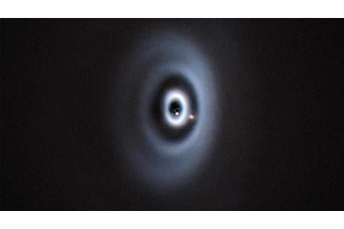 Etwa so könnte es bei der Entstehung der Erde in unserem Sonnensystem ausgesehen haben. Geburt von zwei Planeten (beige Punkte) in einer protoplanetaren Scheibe um den jungen Stern WISPIT 2.