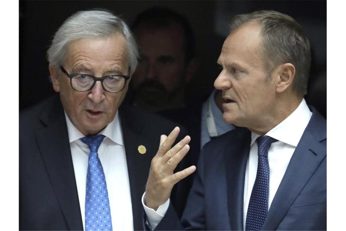 EU-Kommissionspräsident Jean-Claude Juncker (l) und Ratspräsident Donald Tusk nehmen Abschied. Foto: Olivier Matthys/AP/dpa
