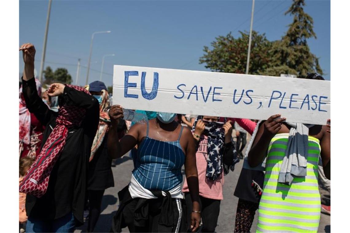 „EU rettet uns, bitte“ steht auf einem Schild, das Migrantinnen und Migranten bei einem Protest auf den Straßen von Lesbos tragen. Foto: Petros Giannakouris/AP/dpa