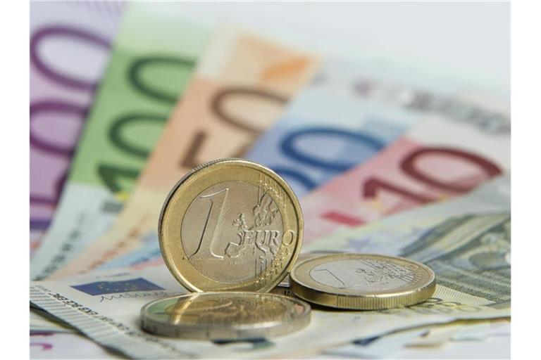Euro-Münzen auf Euro-Banknoten. Foto: Daniel Reinhardt/dpa/Symbolbild