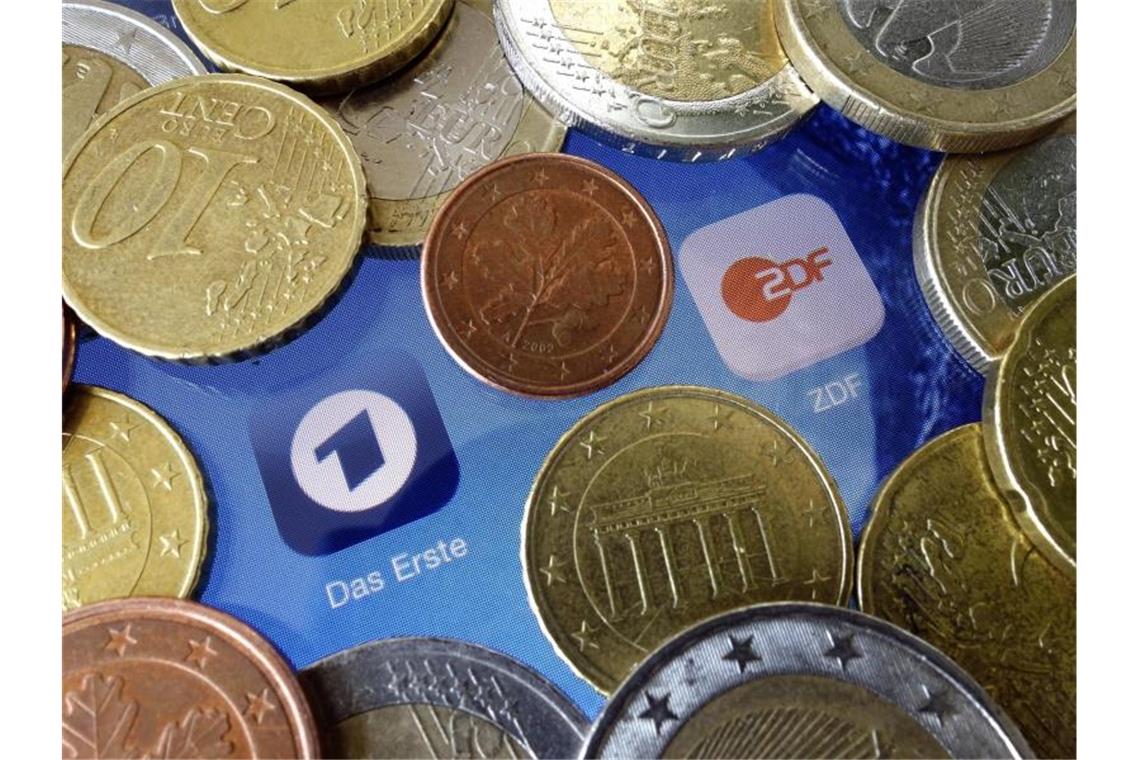 Euromünzen liegen neben den Logos der Apps von ARD und ZDF. Foto: Soeren Stache/dpa