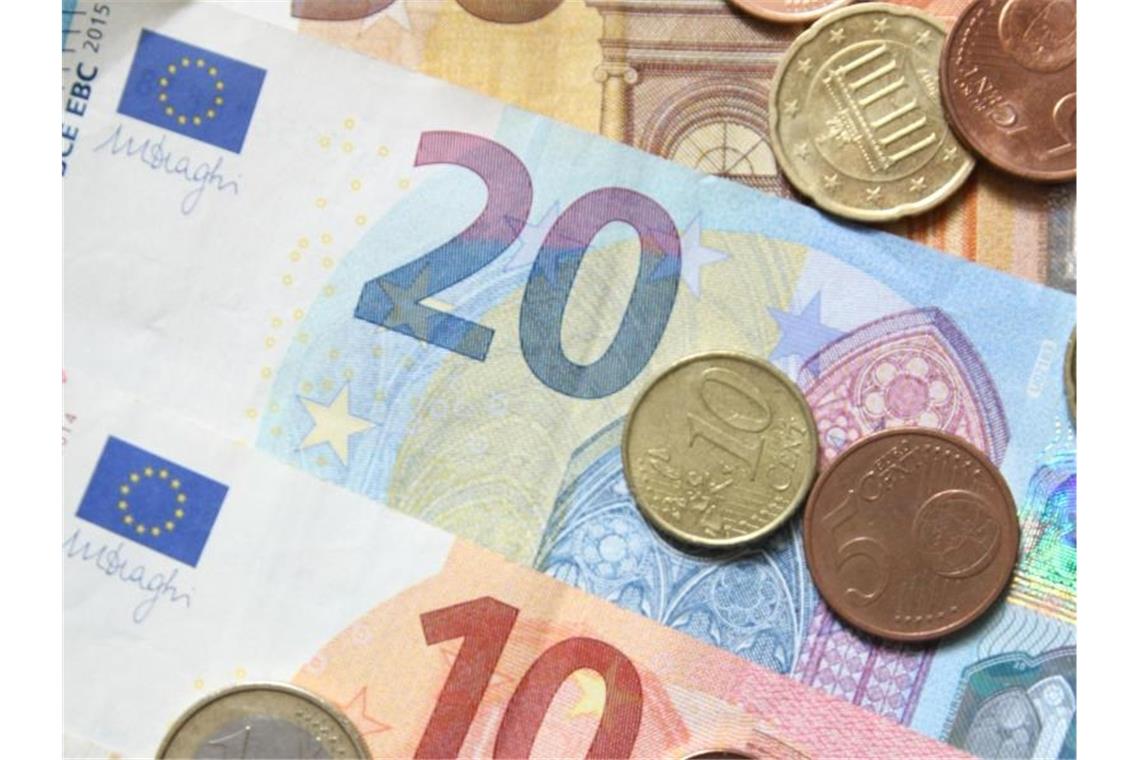 Euros liegen in Münzen und Scheinen auf einem Tisch. Foto: Philipp Brandstädter/dpa/Archivbild