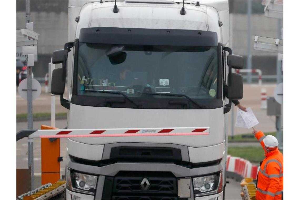 Eurotunnel-Mitarbeiter kontrollieren in Folkestone die Dokumente eines Lkw-Fahrers. Foto: Frank Augstein/AP/dpa