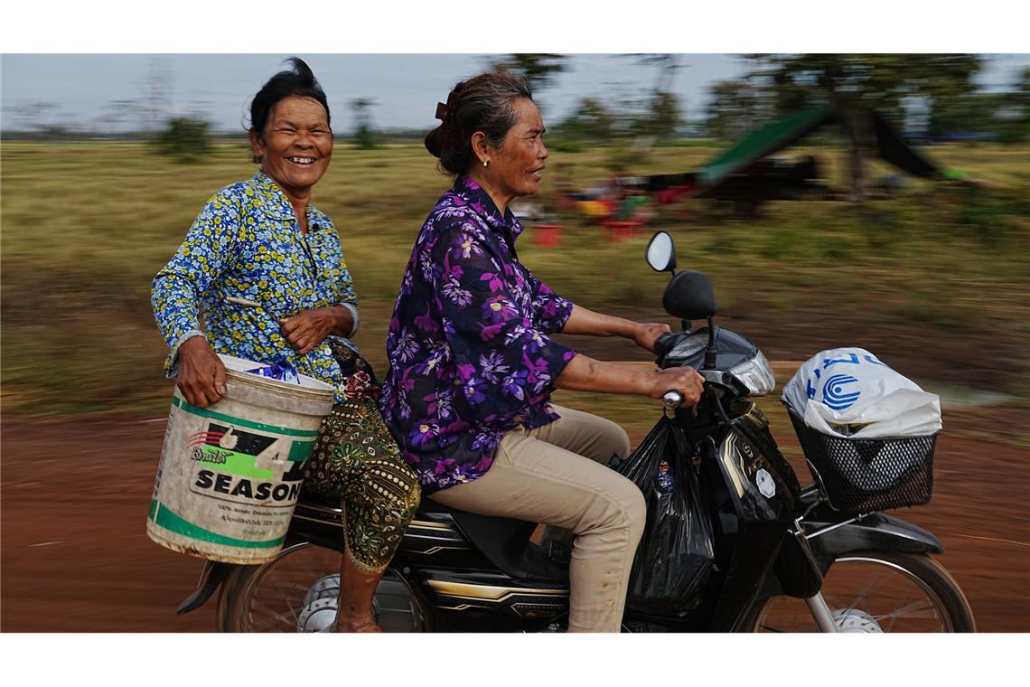 Evakuierte tragen Wasser, als sie auf dem Reisfeld von Chonkal in der Provinz Oddar Meanchey in Kambodscha Zuflucht suchen, nachdem sie nach erneuten Kämpfen zwischen Thailand und Kambodscha aus ihrer Heimat geflohen sind.