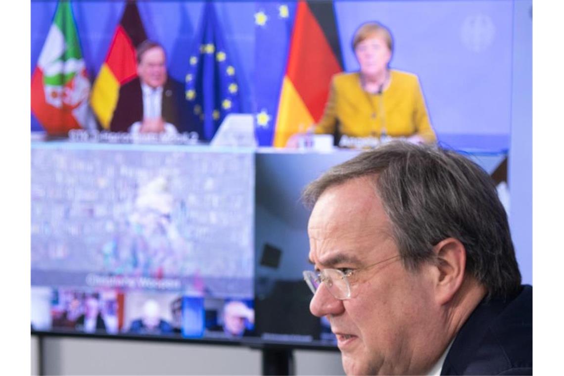 Laschet mahnt vor Corona-Beratungen Einigkeit an Expertenrunde unter den Augen der Kanzlerin: Vor der nächsten Bund-Länder-Runde holte sich NRW-Ministerpräsident Laschet die Einschätzung des Corona-Expertenrats ab. Foto: Federico Gambarini/dpa Pool/dpa