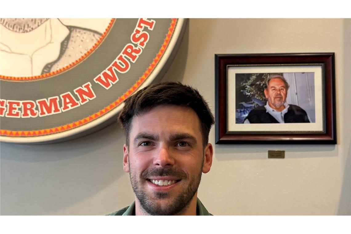 Fabian Förster steht vor einem Foto seines Großvaters, nach dem "Dieters Grill" benannt wurde.