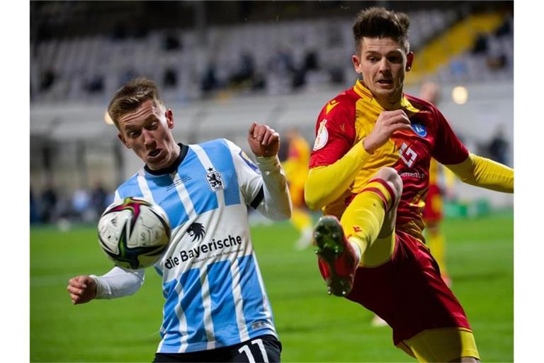 Fabian Greilinger (l) von München und Marvin Wanitzek von Karlsruhe kämpfen um den Ball. Foto: Sven Hoppe/dpa