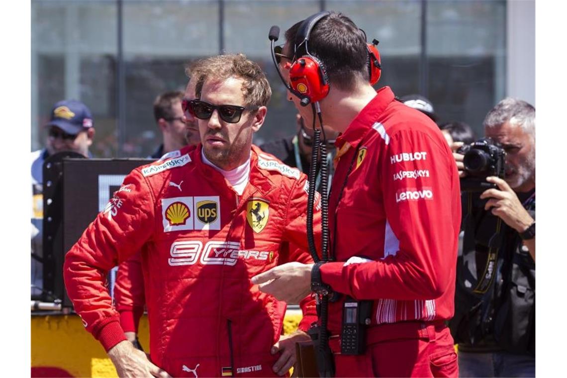 Vettel-Teamchef: Noch keine Lösung für Ferrari-Probleme Fachgespräch: Sebastian Vettel (l) mit einem Techniker seines Ferrari-Teams. Foto: Paul Chiasson/The Canadian Press/AP