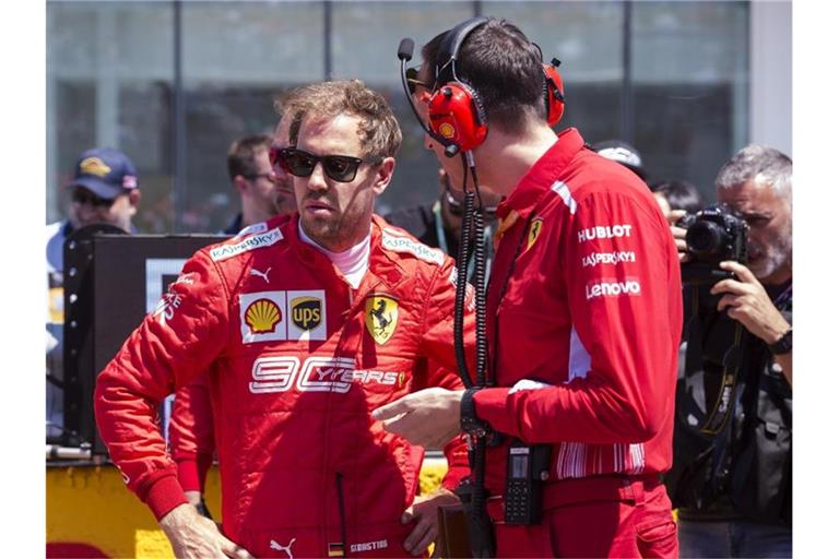 Fachgespräch: Sebastian Vettel (l) mit einem Techniker seines Ferrari-Teams. Foto: Paul Chiasson/The Canadian Press/AP
