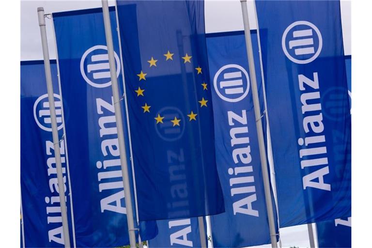 Fahnen des Versicherungskonzerns Allianz wehen vor der Olympiahalle in München. Foto: picture alliance / dpa