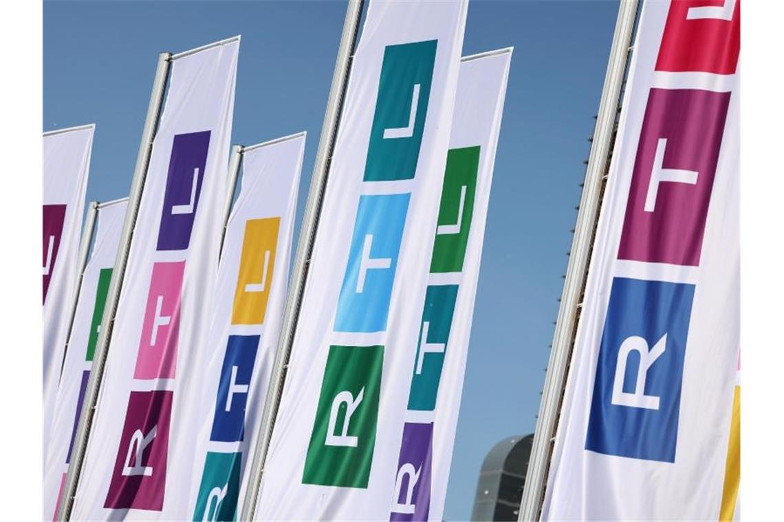 Fahnen mit dem neuen Logo des Fernsehsenders RTL wehen vor dem Gebäude. Foto: Oliver Berg/dpa